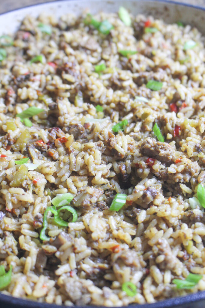 a close up of southern dirty rice in a large cast iron skillet.