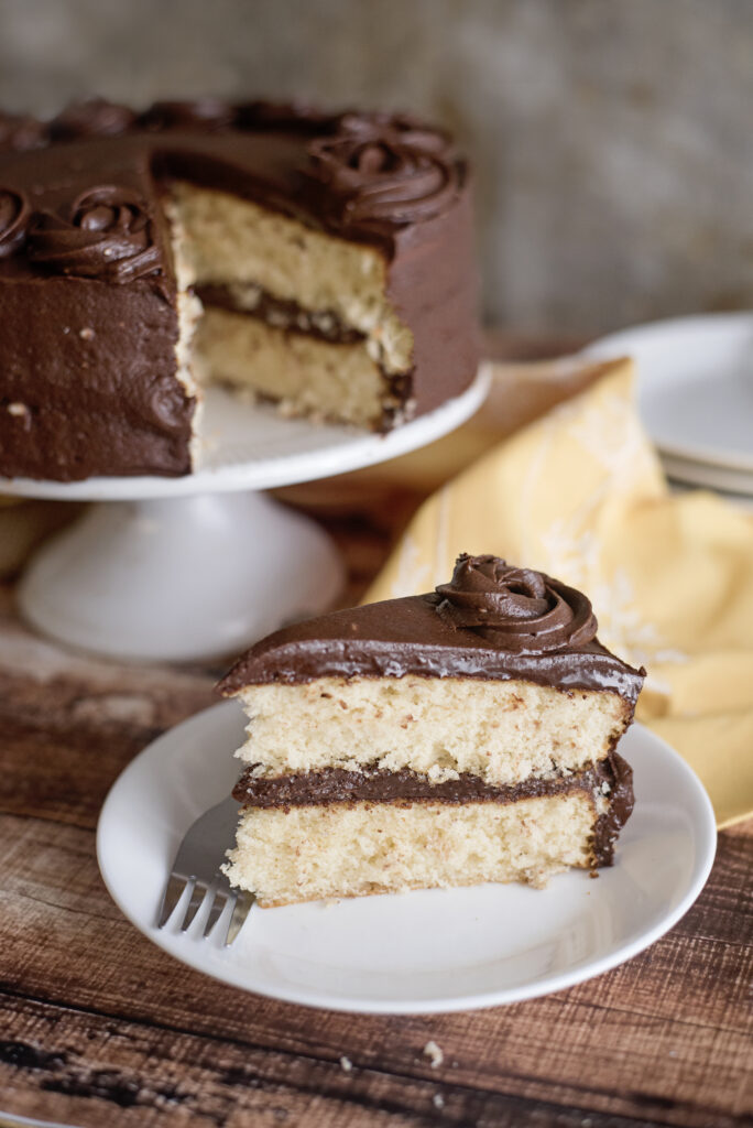 single serving cale on a white plate with main cake in background