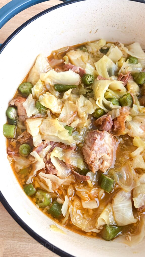 close up of cooked cabbage and okra with smoked turkey.
