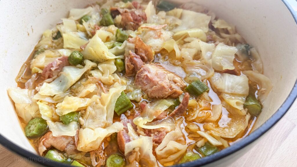 An overhead of southern cabbage and okra in a dutch oven.
