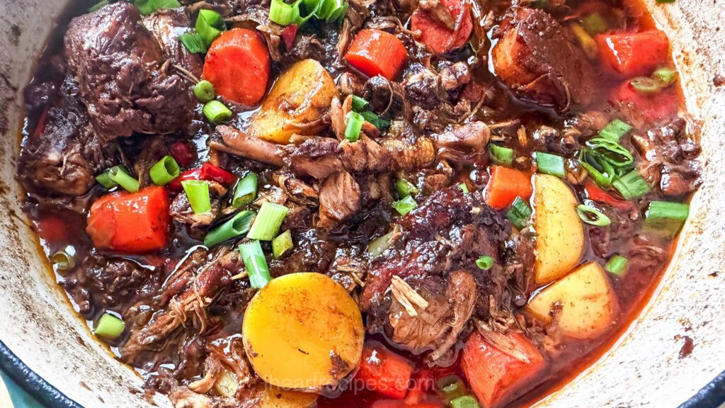 Overhead of dutch oven filled with brown stew and potatoes